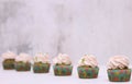 A row of spinach-mint cupcakes with fruit jam and berry cream on top