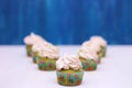 A row of spinach-mint cupcakes with fruit jam and berry cream on top