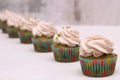 A row of spinach-mint cupcakes with fruit jam and berry cream on top