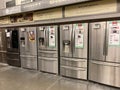 A row of stainless steel french door refrigerators on sale at a Home Depot Store