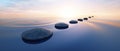 Row of stones in calm water in the wide ocean