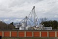 Row of storage units with agricultrual feed storage bins in the background.