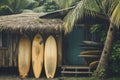 A row of surfboards neatly arranged in front of a traditional hut by the beach, Classic wooden surfboards leaning against a Royalty Free Stock Photo