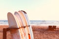 Row of surfboards, two lounge chairs on beach. Royalty Free Stock Photo