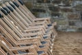 A row of suspended empty deck chairs in rows lined up in order on the beach in the sand