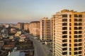 Row of tall apartment buildings and unfinished building with scaffolding along road with parked cars on blue sky copy space Royalty Free Stock Photo