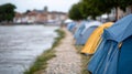 A row of tents lined up along the side of a river Royalty Free Stock Photo