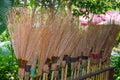 Row of Thai broomstick made of long dried brown coconut leaf for outdoor.