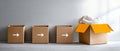 Row of three closed cardboard boxes with white arrows pointing right and one open box with orange flaps and a white blanket inside Royalty Free Stock Photo