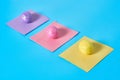 Row of three colorful eggs with glitters and square paper stickers lies on blue desk on kitchen Royalty Free Stock Photo