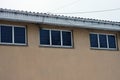 A row of three small windows on a brown concrete wall Royalty Free Stock Photo