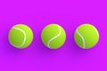 Row of three tennis balls on violet background