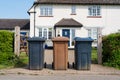 Row of three wheelie bins outside a house