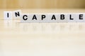 A row of tiles forming the word capable.