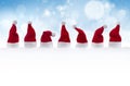 Row of tiny Santa Claus hats in the snow