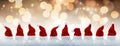 Row of tiny Santa Claus hats in the snow Royalty Free Stock Photo