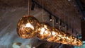 Row of Tom Dixon metallic pendant lights hanging in the Tom Dixon flagship store and showroom at Coal Drops Yard, Kings Cross.