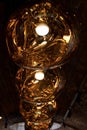 Row of Tom Dixon metallic pendant lights hanging in the Tom Dixon flagship store and showroom at Coal Drops Yard, Kings Cross.