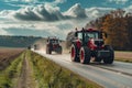 Row of tractors and agricultural machinery drives along the road, surrounded by cultivated fields. Agricultural workers Royalty Free Stock Photo