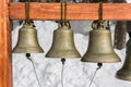 A row of traditional Orthodox bells of different sizes hanging on wooden stand