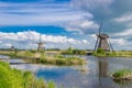 Row of traditional wind mills along blue canal in Kinderdijk, Holland