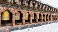 Row of traditional yellow Buddhist prayer wheels in the wall, Bhutan Royalty Free Stock Photo