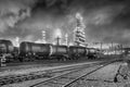 Row of train wagons with an illuminated oil refinery at night in Port of Antwerp, Belgium