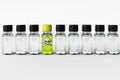 Row of transparent dropper bottles with one green exeption Royalty Free Stock Photo