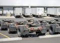 Row of trolleys with axles and fifth wheel tow hitch for semi trucks trains standing on the warehouse parking lot with semi