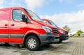 Row of two red delivery and service vans in front of factory delivery parcel hub center Royalty Free Stock Photo