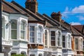 A row of typical British terraced houses in London with overhead cable lines