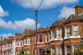 A row of typical British terraced houses in London with overhead cable lines
