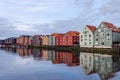 A row of typical colourful Norwegian houses built on pillars on top of a water surface.