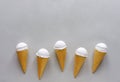 Row of vanilla ice cream cones on gray Royalty Free Stock Photo
