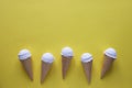 Row of vanilla ice cream cones on yellow Royalty Free Stock Photo