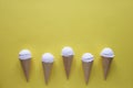 Row of vanilla ice cream cones on yellow Royalty Free Stock Photo