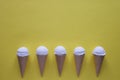 Row of vanilla ice cream cones on yellow Royalty Free Stock Photo