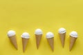 Row of vanilla ice cream cones on yellow Royalty Free Stock Photo