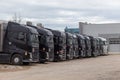 Row of various company trucks parked at a truck overnight parking