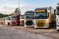 Row of various company trucks parked at a truck overnight parking somwehere along the E30 highway. Germany - June 14, 2019