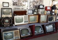 A row of various obsolete antique TVs stacked in several tiers on top of each other