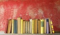 Row of vintage books on red background