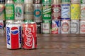 A row of vintage Pepsi, Coca-Cola aluminium cans with the cans background located on the wooden table