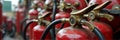 Row of vintage red fire extinguishers with brass valves Royalty Free Stock Photo