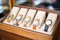 row of vintage watches on display in a wooden case