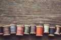 Row of vintage spools of multicolored threads on wooden board. View from above. Copy space for text