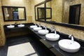 Row of wash basins with mirrors in a public toilet Royalty Free Stock Photo