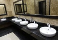 Row of wash basins with mirrors in a public toilet Royalty Free Stock Photo