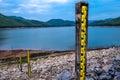 Row of water level gauges with view of the lake and mountain on a cloudy day. Royalty Free Stock Photo