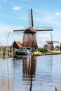 A row of water windmills on the river. Beautiful wind mills landscape. Windmill sails are moving by wind. Ecological energy